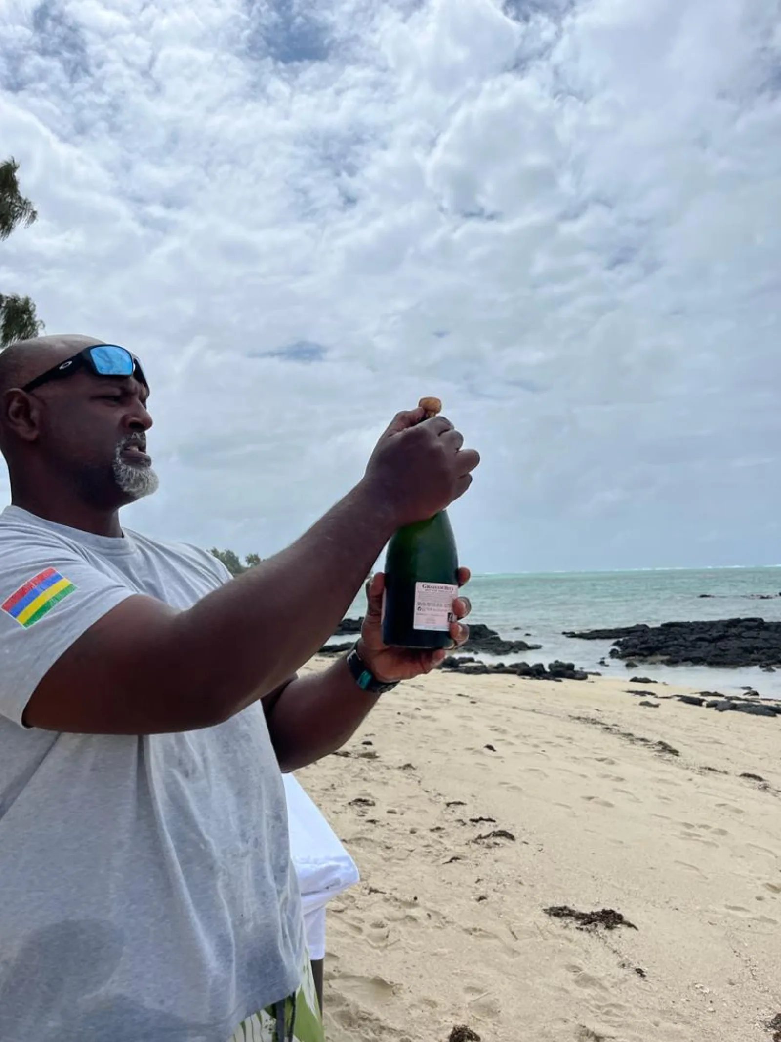 Ouverture du champagne sur la plage au coucher du soleil